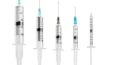 Five medical syringes, arranged by size from largest to smallest, on a white background.