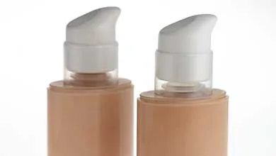 Two identical bottles of beige liquid foundation with white pump dispensers on a white background.