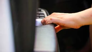 Close-up of a hand gripping a car dashboard