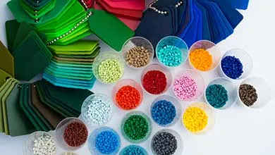 Clear cups filled with colorful plastic pellets are arranged beside matching color swatches, all displayed on a white background.